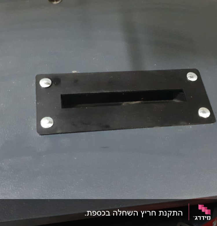 חריץ מתכת עם ברגים על משטח אפור